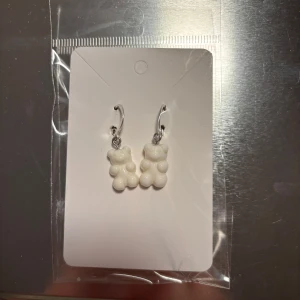 Vita örhängen med björndesign - Söta vita örhängen formade som björnar. Perfekta för att lägga till en lekfull touch till din stil. De hänger från en enkel silverfärgad krok. (Billigt material) 