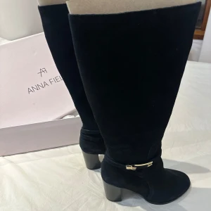 Svarta stövlar från Anna Field - Snygga svarta stövlar från Anna Field i mocka med en elegant klack och dekorativt spänne. Perfekta för att ge en stilren touch till din outfit.