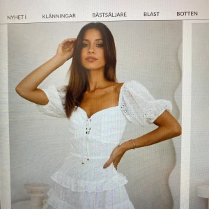 Vit spetsklänning från Hello Molly - Charmig vit spetsklänning från Hello Molly med volanger och snörning framtill. Klänningen har korta ärmar och en vacker broderad design. Perfekt för sommarens festligheter. Aldrig använd pågrund av för liten.  Perfekt till studenten!! Köptes för 800kr 