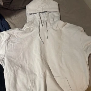 Ljusblå hoodie - Säljer en klassisk vit hoodie med justerbar huva och känguruficka framtill. Perfekt för en avslappnad stil. Passar bra till jeans eller träningsbyxor. Den är från Lager 157. Stor i storleken så mer som L än M.
