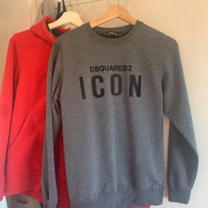 Grå tröja från Dsquared2 - Säljer en stilren grå tröja från Dsquared2 med texten 'ICON' i svart på framsidan. Tröjan har långa ärmar och en klassisk rund halsringning. Perfekt för en avslappnad look.