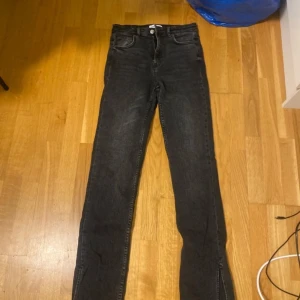 Svarta jeans från Zara - Snygga svarta jeans från Zara med en klassisk design. De har en hög midja och raka ben och slit längst ner, vilket ger en stilren look. Perfekta för både vardag och mer uppklädda tillfällen. 💓💓