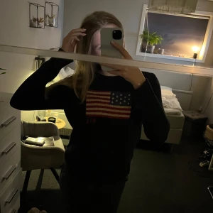 Mörkblå stickad tröja från Ralph Lauren - Säljer en mörkblå stickad tröja från Ralph Lauren med en amerikansk flagga på bröstet. Tröjan köptes nypris för ca 4000 kr och har storlek L men jag själv skulle säga att den passar endast XS/S i dam och herr storlek.