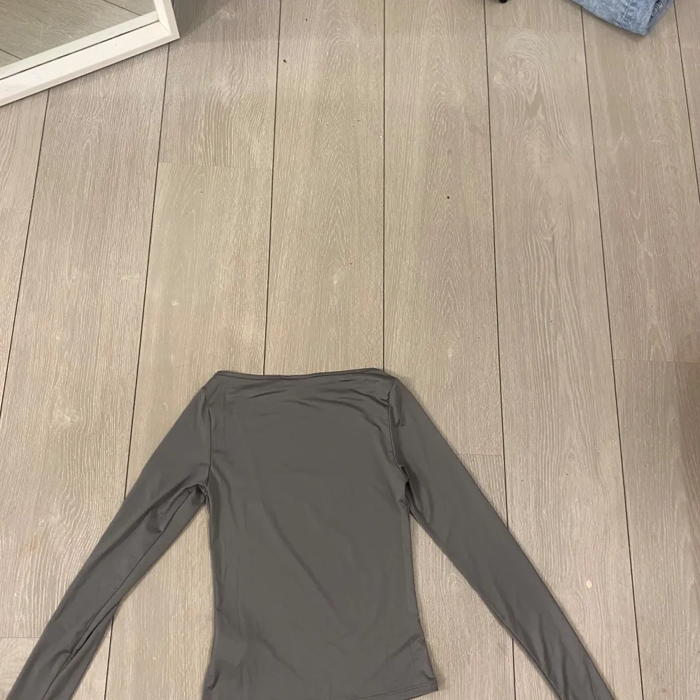 Säljer en stilren grå långärmad topp från monki. Toppen har en enkel design med en rund halsringning.. Yläosat.