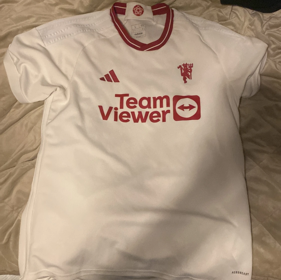 Vit fotbollströja med röda detaljer Manchester United