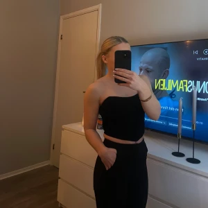 Svart axelbandslös tubtopp - En snygg svart axelbandslös tubtopp/korsett topp som passar perfekt för en stilren look. Toppen är lite croppad och passar perfekt till festliga tillfällen. 🤩