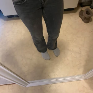 Grå bootcut jeans - Snygga grå bootcut jeans med klassisk femficksdesign. De har en bekväm passform och är perfekta för en avslappnad stil. Jeansen har en knapp- och dragkedjestängning framtill.