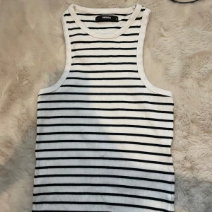 Randig ribbad linnetopp från Bik Bok - Snygg och stilren randig linnetopp från Bik Bok i svart och vitt. Toppen är ribbad och ärmlös, perfekt för en avslappnad look. Passar bra till både jeans och kjol.