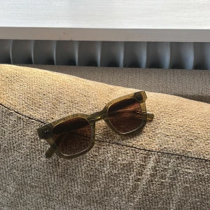 Solglasögon från CHIMI - Snygga solglasögon från CHIMI med en fyrkantig form och transparent brun båge. Perfekta för att ge en cool touch till din stil. Kommer med originalförpackning och fodral.