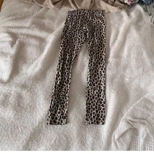 Leopardmönstrade leggings från Lindex - Säljer ett par coola leopardmönstrade tights från Lindex. Perfekta att ha under Jensen när det är kalt eller bara som de är.  De är bekväma och stretchiga.  Bra skick. Inga hål. Inga fläckar. 
