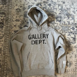 Grå hoodie från Gallery Dept. - Tja! Säljer en riktigt fet gallery dept hoodie i storlek S. Den sitter lite störe så passar även M. Säljs p.g.a att jag bytt stil och den ej kommer till användning. Jätte fint skick och original taggar kommer med. Pris kan diskuteras