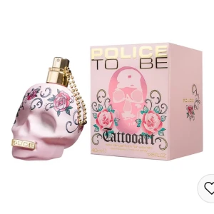 Police To Be Tattooart EdP 40ml  - Upptäck Police To Be Tattooart, en unik parfym i en rosa dödskalleformad flaska dekorerad med blommor och pärlor. Denna doft för kvinnor kombinerar fruktiga och blommiga noter för en djärv och uttrycksfull upplevelse. Perfekt för den som vill sticka ut med stil.