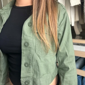 Grön croppad jacka - Snygg grön croppad jacka från Cubus med klassisk krage, stora knappar framtill och två bröstfickor! Använd ett fåtal gånger men inga direkta tecken på användning. Gillar den jättemycket men tycker den är en aning för liten. Den är i barnstorlek så passar nog bäst på någon lite yngre. Men det beror ju på hur man vill den ska sitta såklart!☺️💕