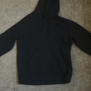 Svart hoodie från Peak Performance - Säljer en svart hoodie från Peak Performance i storlek S. Perfekt för en avslappnad stil och enkel att matcha med det mesta. Är i väldigt bekvämt fleece-polyester material. Den är i använt skick med liten defekt på en snöret (se bild 4). Köparen står för frakt. Hör av dig vid frågor!