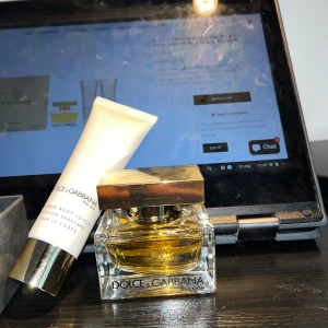 Dolce & Gabbana The One EdP parfym och body lotion - Säljer en lyxig parfymflaska Dolce & Gabbana The One EdP tillsammans med en matchande body lotion. Parfymen kommer i en elegant glasflaska med guldigt lock och gyllene vätska. Body lotionen är i en vit tub med guldigt lock. (Kan säljas separat)  50 ml oanvänd handcream och 26 av 30 ml för parfymen.