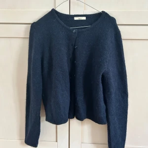 Mörkblå stickad kofta från Gina Tricot - Mysig mörkblå stickad kofta från Gina Tricot i storlek M, från Premium kollektionen. Koftan har rund halsringning, långa ärmar och knäppning framtill med flera knappar. Är av lyxigt material