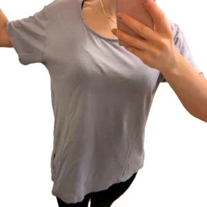 Ljusgrå t-shirt från Pull&Bear - En basic ljusgrå t-shirt från Pull&Bear med rund halsringning och korta ärmar. T-shirten har en avslappnad passform och är tillverkad i mjuk bomull, perfekt för en enkel och stilren look.