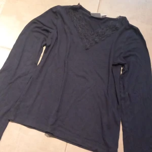Marinblå långärmad topp med spetsdetalj storlek 146/152 - Säljer en marinblå  långärmad topp med v-ringning och fin spetsdetalj framtill. Perfekt för dig som gillar enkla men snygga plagg med lite extra detalj vid halsen. Mjuk och skön att ha på sig. 😊