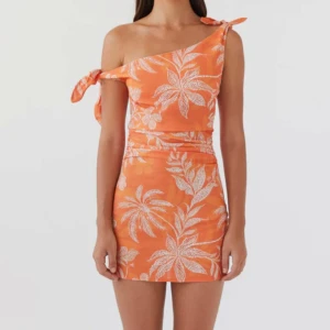 Orange mönstrad klänning från Peppermayo - Säljer en orange kortklänning från Peppermayo med mönster. Klänningen har one shoulder-design med knyt på axeln och är i linne. Den är så snygg men var tyvärr för liten för mig.