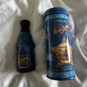 Versace Blue Jeans Man Eau de Toilette 75 ml - Versace Blue Jeans Man är en ikonisk herrparfym i blå glasflaska med tillhörande blå metallburk. Doften är fräsch och maskulin, och flaskan rymmer 75 ml. Perfekt för dig som gillar klassiska och stilrena dofter. parfymen är använd lite men gissar på att det är ungefär 60-70 ml kvar i flaskan!