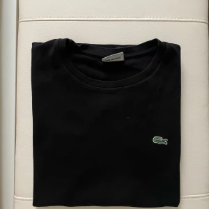 Svart t-shirt från Lacoste - Säljer en svart T-shirt från Lacoste i Storlek M. Tröjan är i perfekt skick, skriv om ni har frågor om pris eller annat👍🏼👍🏼