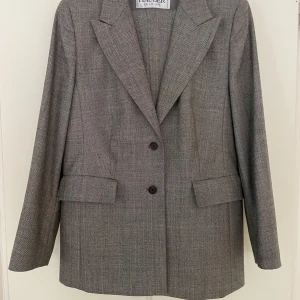 Vintage ullkostym från Hauber - Köpt i vintagebutik men sen tyvärr aldrig blivit. En klassisk grå rutig kostym från Hauber.  Fint skick förutom ett litet hål på armen, tänkte inte själv på det när jag köpte men syns om man synar noga.   Ca mått: - axel till axel ca 41 cm (mätt framifrån, hängande på galge)   -kavajlängd ca 72 cm (mätt från axelsöm till nederkant) -  Midjemått/omkrets kavaj ca 99 cm - Midjemått byxor (mätt byxlinningen) ca 90 cm Byxorna har rejäl sömsmån bak så går även att sy om till både större & mindre mått