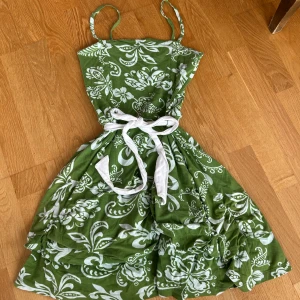 Grön blommig klänning - Säljer denna klänningen som jag köpt från Sellpy som aldrig kommit till användning. Väldigt bekvämt material som är perfekt nu inför lite varmare dagar! Skulle säga att den passar storlek s-m då materialet är hyfsat stretchigt!🤗
