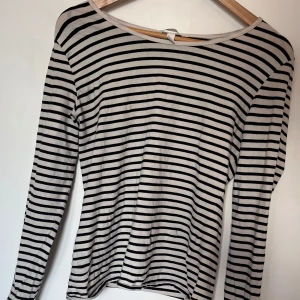 randig svart och vit långärmad tröja  - Snygg och enkel långärmad tröja med svarta och vita horisontella ränder. Tunn och mjuk i materialet, perfekt till våren eller att ha under en jacka. Använd men i fint skick – inga fläckar eller hål. Passar M-L beroende på önskad passform.