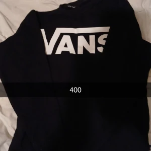Svart sweatshirt från Vans - Säljer en svart sweatshirt från Vans med stor vit logga framtill. Klassisk modell med rund hals och långa ärmar. Perfekt för en avslappnad streetstil. Tar endast kontant möts I Eskilstuna Örebro Arboga.