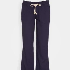 Mörkblå linnebyxor  - Snygga mörkblå linnebyxor med avslappnad passform och vit snörning i midjan. Byxorna har raka ben och resår i midjan för extra komfort. Perfekta för en chill och stilren look. Använda endast 2 gånger och är som nya förutom att jag sprätt upp sömmen längst ner för att de ska bli längre. Storlek m men passar även S. Hör av er vid frågor🥰