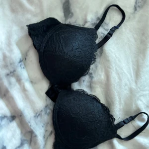 Svart spets-bh från Intimissimi - Säljer en svart bh från Intimissimi med vacker spetsdetalj. Bh:n har justerbara axelband och vadderade kupor för extra komfort och stöd. Perfekt för dig som vill ha en elegant och stilren underklädeslook.