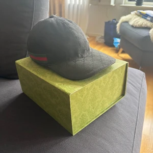Svart keps från Gucci - Säljer en svart gucci keps, hade fått den i födelsedagspresent men den passa inte mig och har använt den en gång när jag testa annars så är den som ny, nypris ligger på 5650kr. Den har inga skador alls och är precis som ny den är 1 vecka gammal. Och så klart så är den äkta alla äkthetsbevis har jag.