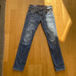  Replay Anbass - Säljer ett par klassiska blå Replay Anbass jeans med fem fickor och raka ben. Byxorna har snygga slitningar och en läderpatch med Replay-logga bak i midjan. Passar perfekt till vardags och har en tidlös look.  Kan pruta!!!