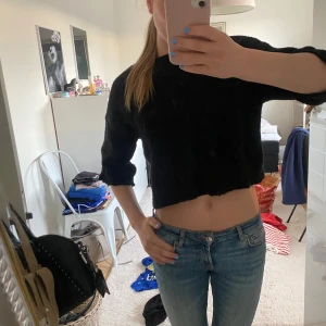 Svart stickad tröja - Säljer en svart  stickad tröja med trekvarts ärmar. Tröjan har en enkel och stilren design, perfekt att matcha med jeans eller kjol. Mjuk och skön att bära.