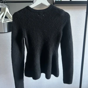 Figursydd tröja - En svart stickad tröja från H&M med rund halsringning och långa ärmar som är något figursydd. Sällan använd☺️