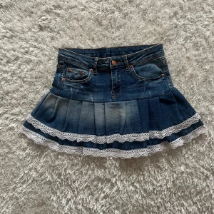 Jeanskjol med spetskant och volang - Lågmidjad jeanskjol omsydd från ett par jeans.  Midjemått tvärsöver- 33cm Längd-32cm