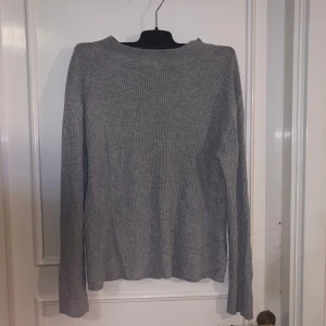 Grå ribbad tröja från Atmosphere - Mysig grå ribbad tröja från Atmosphere. Tröjan har lång ärm och en klassisk rak passform. Perfekt att styla med jeans eller kjol för en enkel och stilren look.