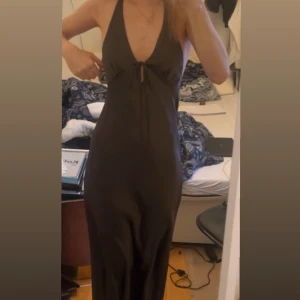 Långklänning med halterneck - Säljer en khaki färgad långklänning med halterneck och liten knutdetalj framtill. Perfekt inför sommaren eller som en balklänning💕😊