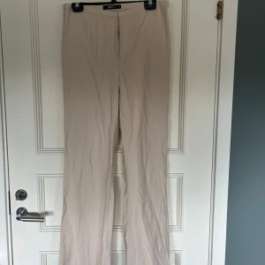 Beige kostymbyxor från Gina Tricot - Säljer ett par stilrena beige kostymbyxor från Gina Tricot. Byxorna har raka ben, perfekt för en clean och enkel look. Passar dig som gillar klassiska och tidlösa plagg. Det är endast använda en gång till ett White party. de är i storlek 40 men jag är vanligtvis S eller M och valde att ha dem som lite mer baggy💞