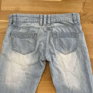 Ljusblå jeans  - Ljusblå jeans med raka ben och låg midja. Bakfickorna är dekorerade med små silverfärgade nitar. Insydd slits i midjan för att göra de större. Midjemått är 38 cm. Köpa här på Plick!💗