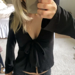 Knyttröja - Svart långärmad omlottopp från Gina Tricot med djup v-ringning och knyt framtill💕