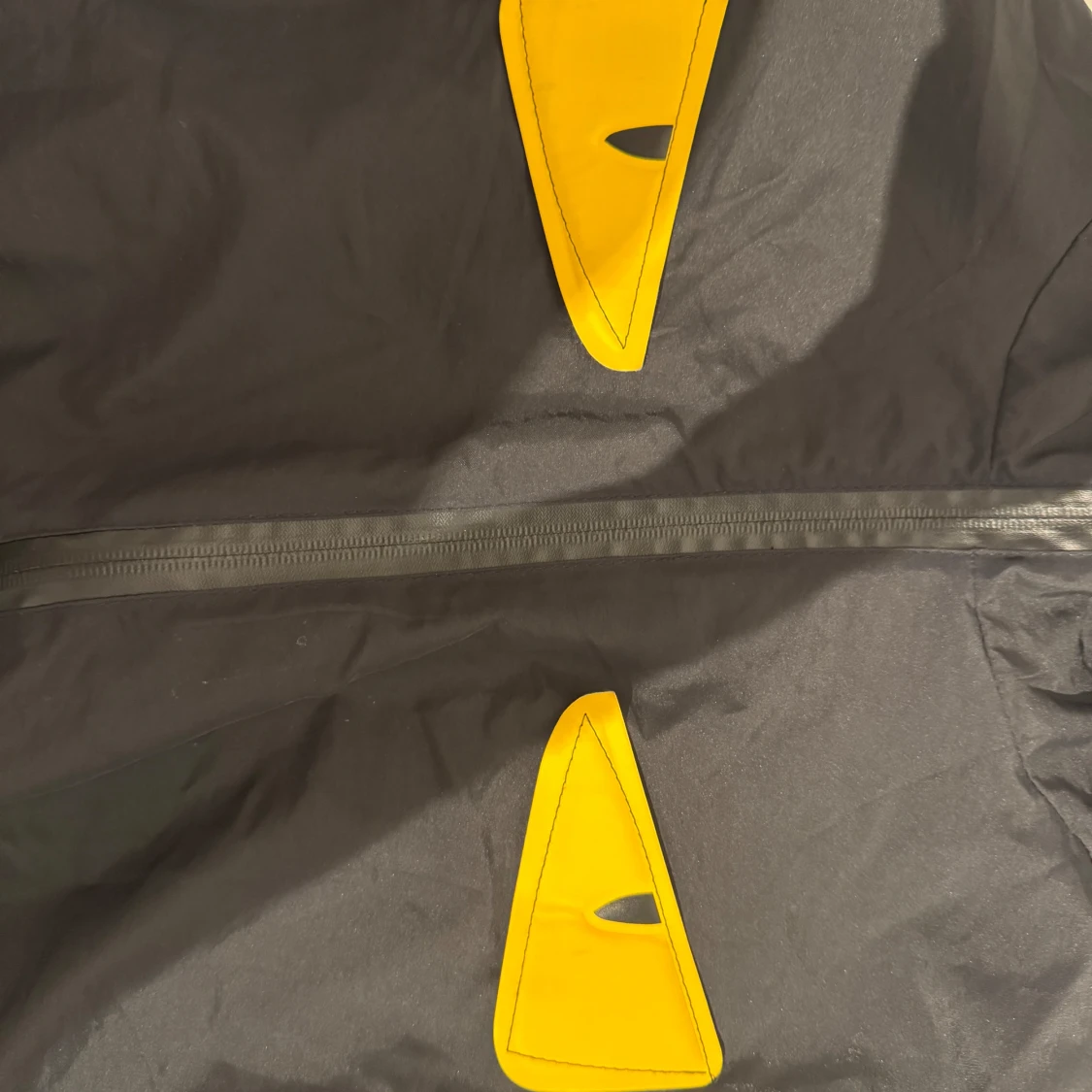 Svart vindjacka med gula ögon-detaljer - 1