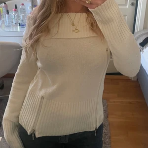 Off shoulder med dragkedjor - Vit stickad tröja med ribbade detaljer och dragkedjor på sidorna. Står ej vilken storlek men skulle säga S/M