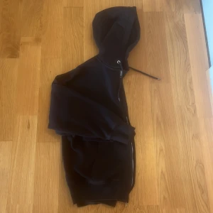 Svart oversized hoodie från H&M - Säljer en svart hoodie från H&M i oversized fit. Tröjan har dragkedja framtill, huva med snörning och två fickor. Perfekt för en avslappnad stil och enkel att matcha med andra plagg.