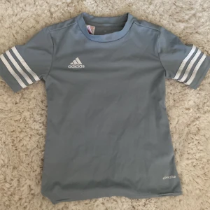 Ljusblå sportig t-shirt från Adidas - Jag säljer denna tränings tröjan från adidas. Ser inga defekter på. Några frågor?, skriv gärna till mig då!