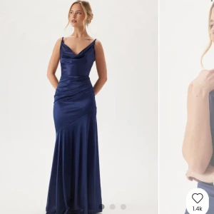 Marinblå långklänning i satin - Säljer en elegant marinblå långklänning i glansigt satinmaterial. Klänningen har smala axelband, draperad urringning och figurnära passform som faller snyggt längs kroppen. Perfekt för bal eller festkväll! Helt ny med prislapparna kvar! Totalt slutsåld på hemsidan!