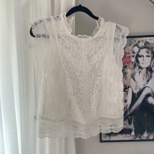 Vit spetsblus med volangdetaljer - Superfin vit blus i spets med vackra volangdetaljer. Den är lite missfärgad vid kragen men går lätt att tvätta bort!❤️