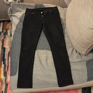 Svarta jeans från Nudie - Säljer riktigt feta nudie jeans i färgen svart, skicket är mycket bra och nästan som nytt. De sitter bra på benet och är i storleken 30/30, pris kan diskuteras 