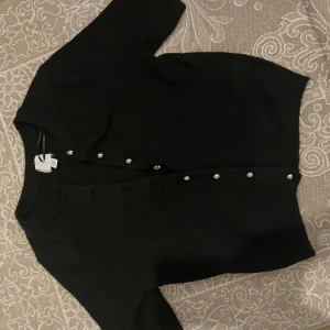 Svart kofta med pärlknappar H&M - Svart kortärmad, kofta med silverknappar från hm🩷 stl XXS. aldrig använt! Hör av er om ni vill köpa!!