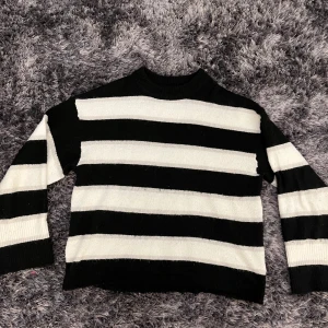 Randig svartvit stickad tröja H&M Divided - Perfekt för dig som gillar en enkel men ändå cool stil. Materialet är mjukt och skönt mot huden men gör dig inte allt för varm. Använt några gånger. 🤍